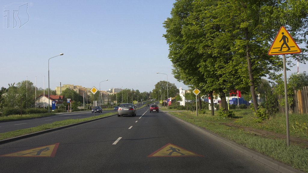 Sytuacja drogowa — pytanie 1001: Czy w przedstawionej sytuacji jesteś ostrzegany o zbliżaniu się do wyznaczonego na drodze przejścia dla pieszych?