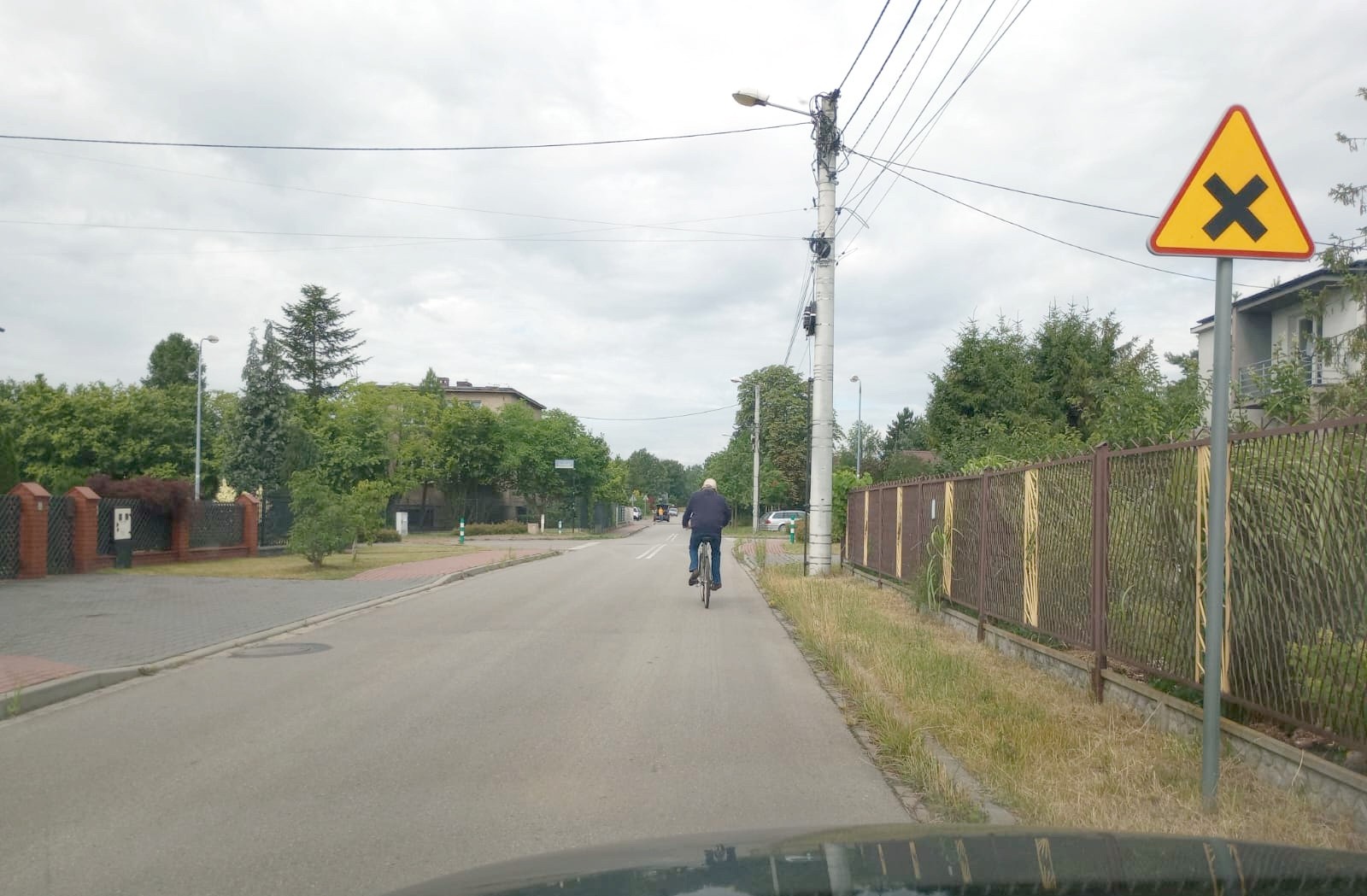 Sytuacja drogowa — pytanie 13503: Czy w tej sytuacji, mimo że zakaz wyprzedzania rowerzysty nie obowiązuje na skrzyżowaniu, powinieneś powstrzymać się od wyprzedzania rowerzysty, gdyż ze względu na ograniczoną widoczność mogłoby ono doprowadzić do stworzenia zagrożenia bezpieczeństwa ?