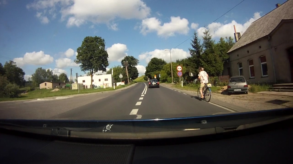 Sytuacja drogowa — pytanie 9560: Czy w przedstawionej sytuacji możesz wyprzedzić rowerzystę jeśli będzie to wymagało nieznacznego przekroczenia linii podwójnej ciągłej?